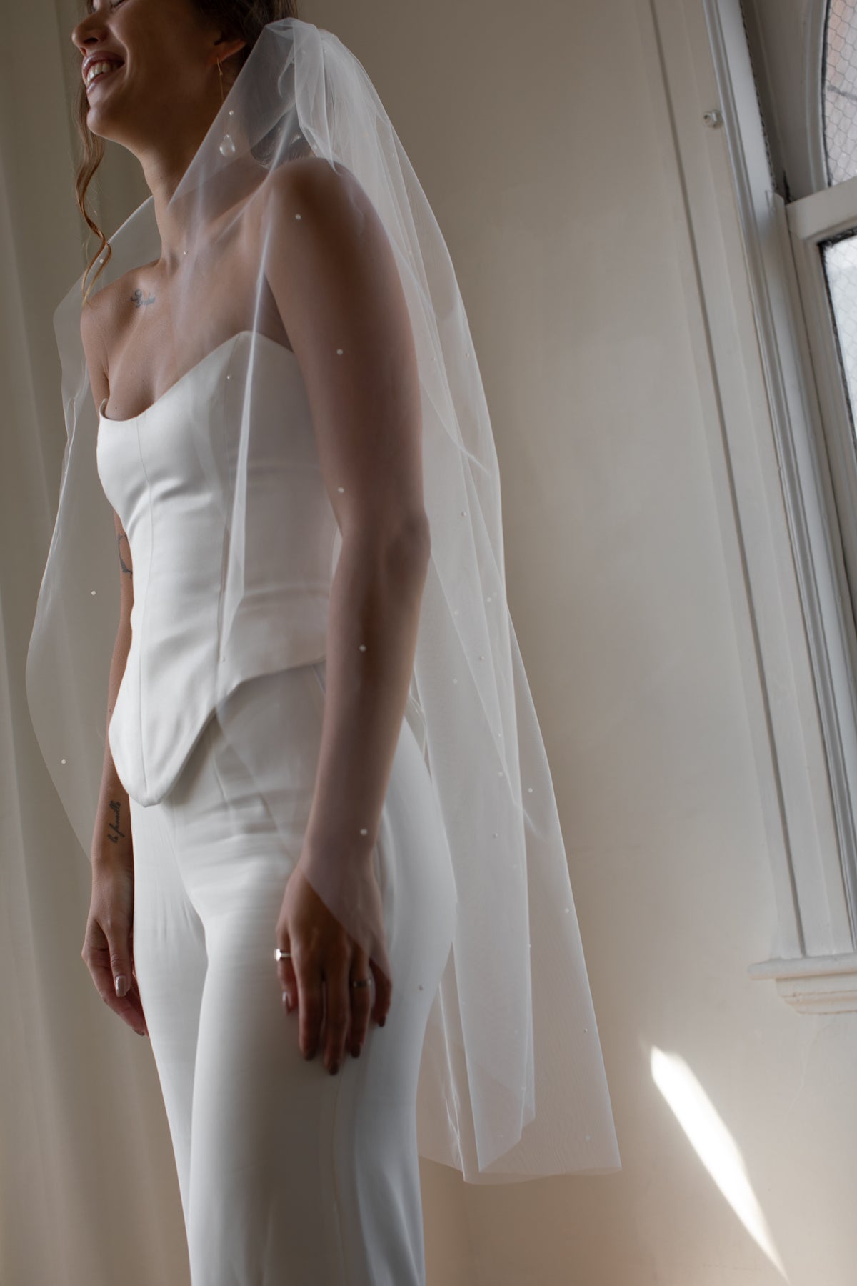 Bride wearing the Eden pearl fingertip veil by TEMPÊTE
