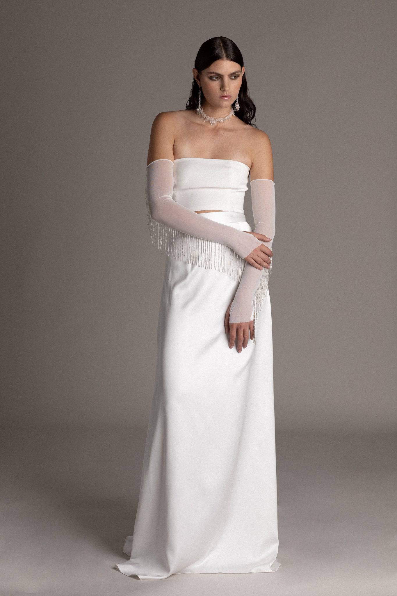 Model is wearing a skirt set with fringe gloves by TEMPÊTE