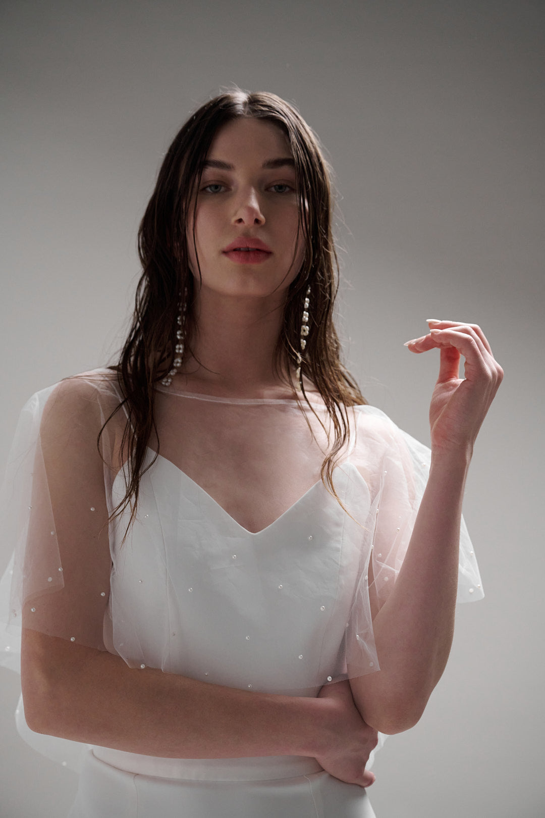 Iris Cape - a sheer and refined pearl cape that brings an elegant flair to any wedding day look, without upstaging the dress. Featuring tiny glistening pearls, this cape is a perfect accessory for a minimal but impactful statement