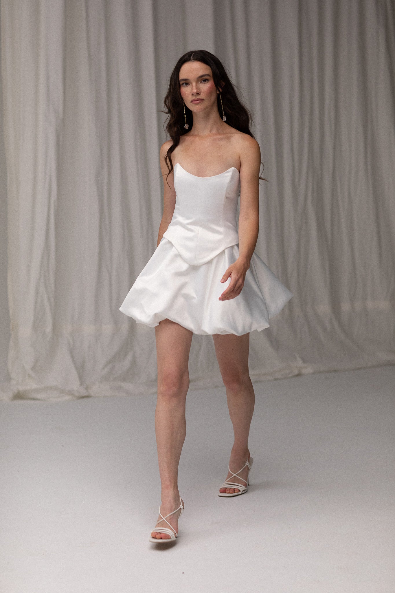 Detailed view of a satin mini bubble skirt, highlighting its playful silhouette and luxurious fabric, perfect for an unconventional bridal style