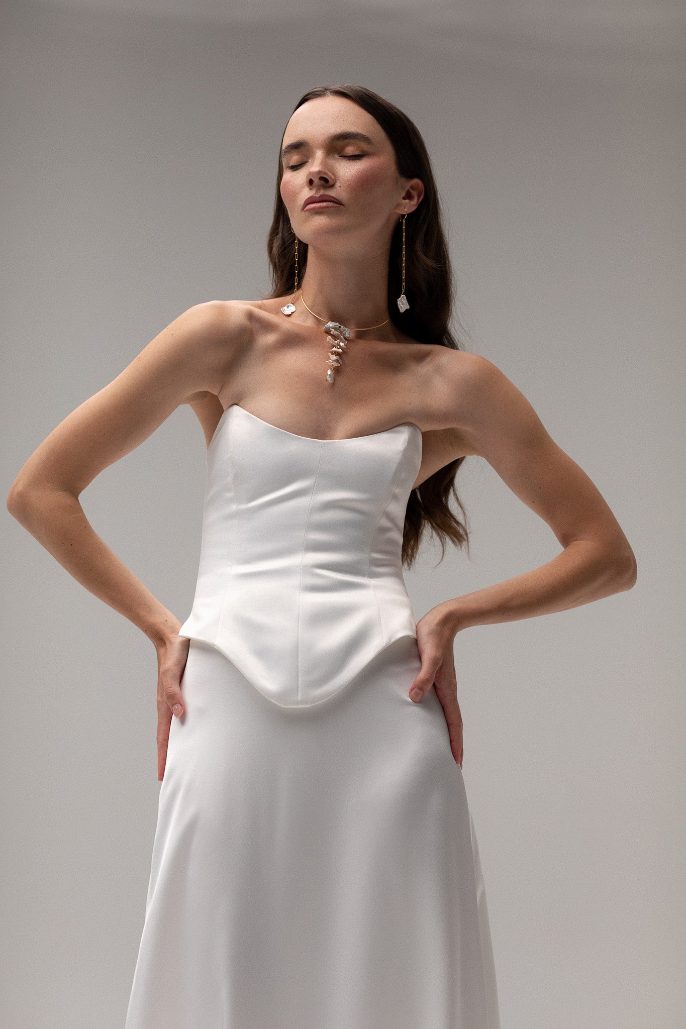 Model is wearing a satin corset top from TEMPÊTE, showcasing a sleek and tailored fit for a bold bridal outfit.