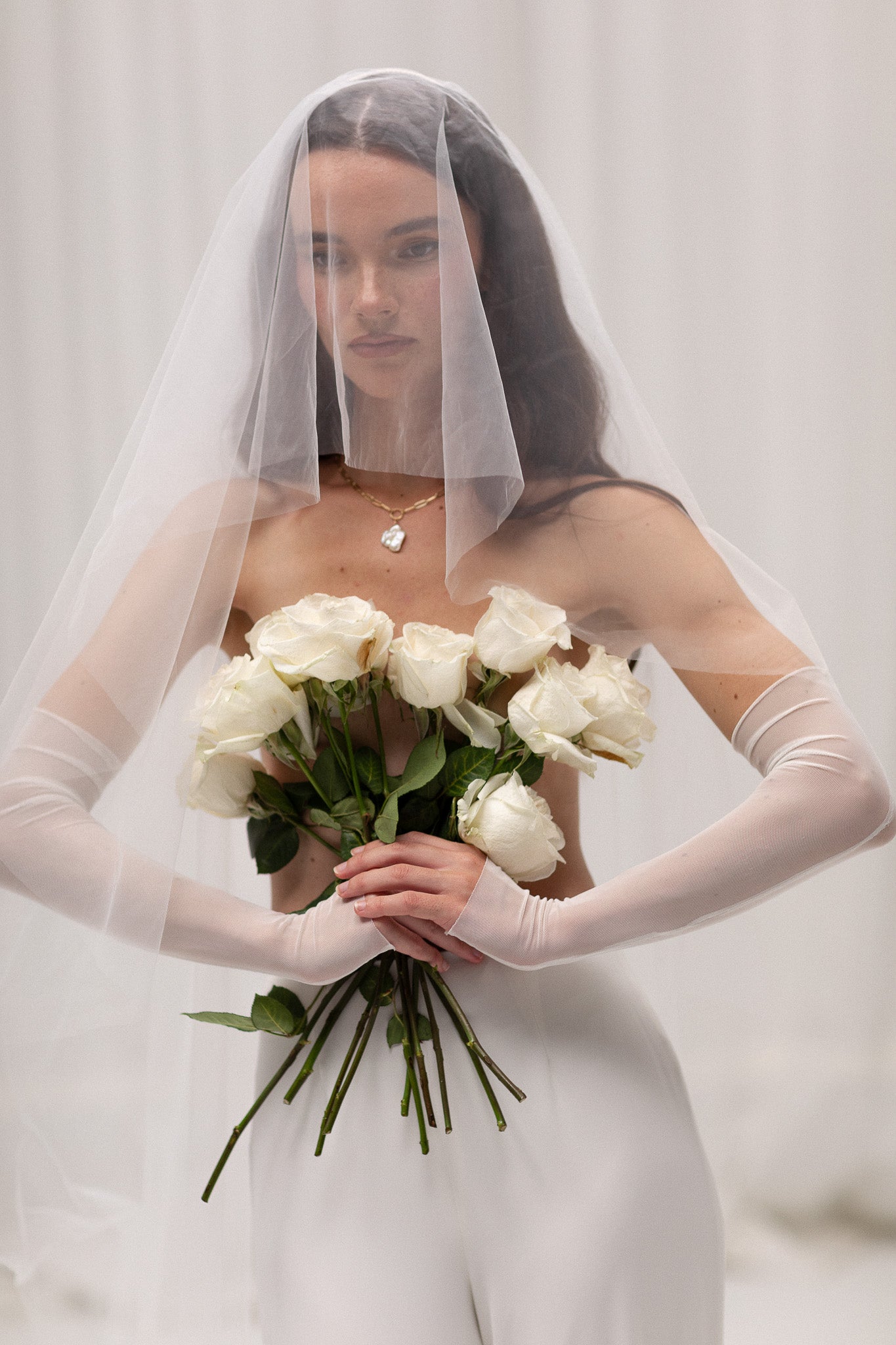 Bride in TEMPÊTE’s short blusher tulle veil, showcasing a minimal design that pairs beautifully with any bridal look