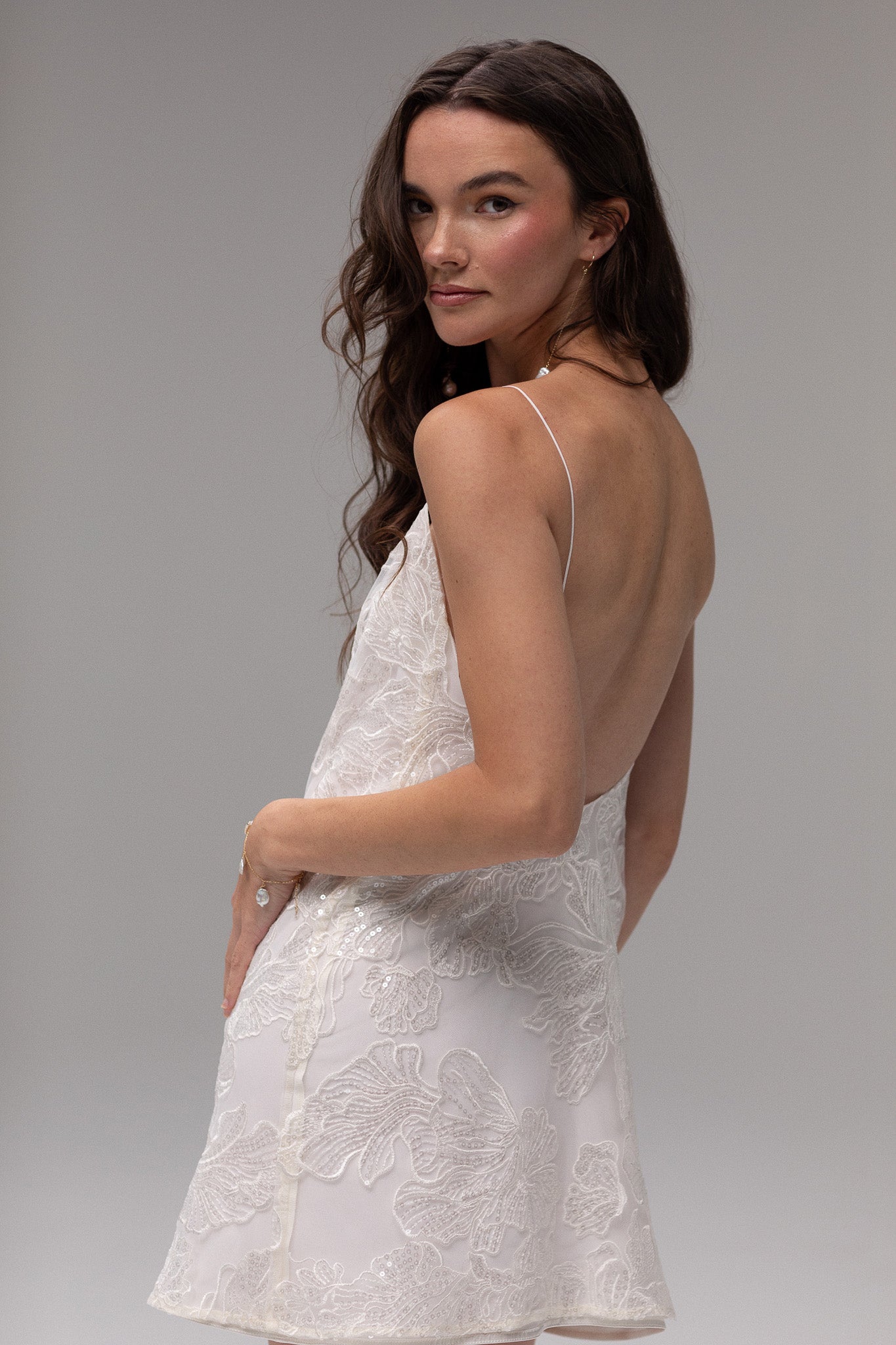 Detailed view of TEMPÊTE mini bridal dress with delicate sequin lace, spaghetti straps, and an open back, ideal for a chic after-party look