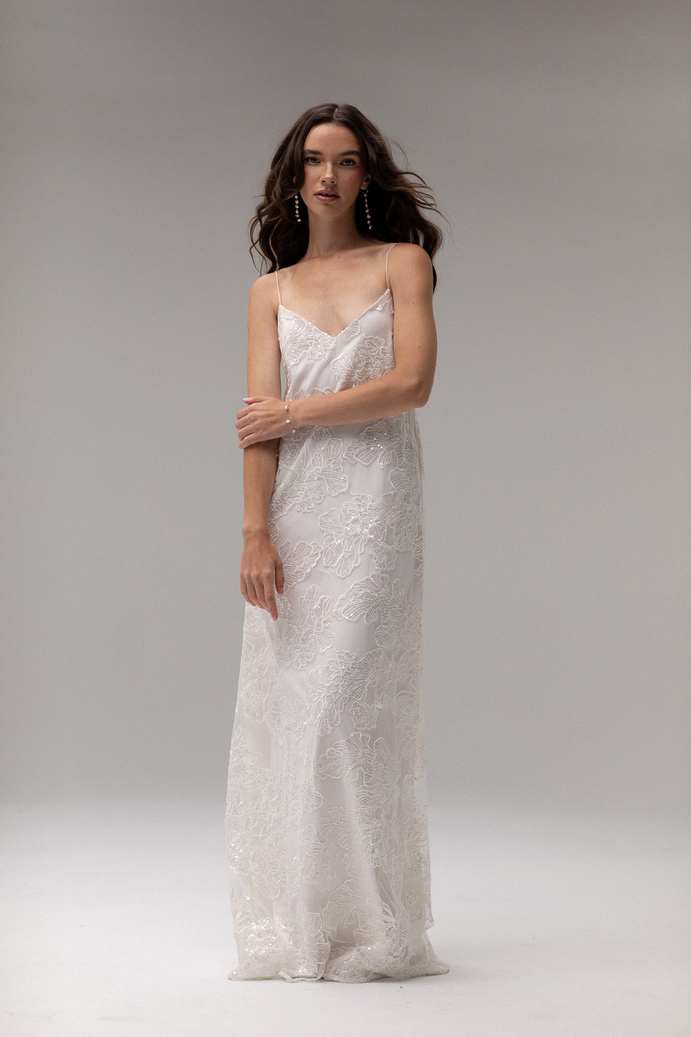 Detailed view of TEMPÊTE maxi bridal dress with delicate sequin lace, v-neck design, spaghetti straps, and an open back, ideal for a modern bridal look