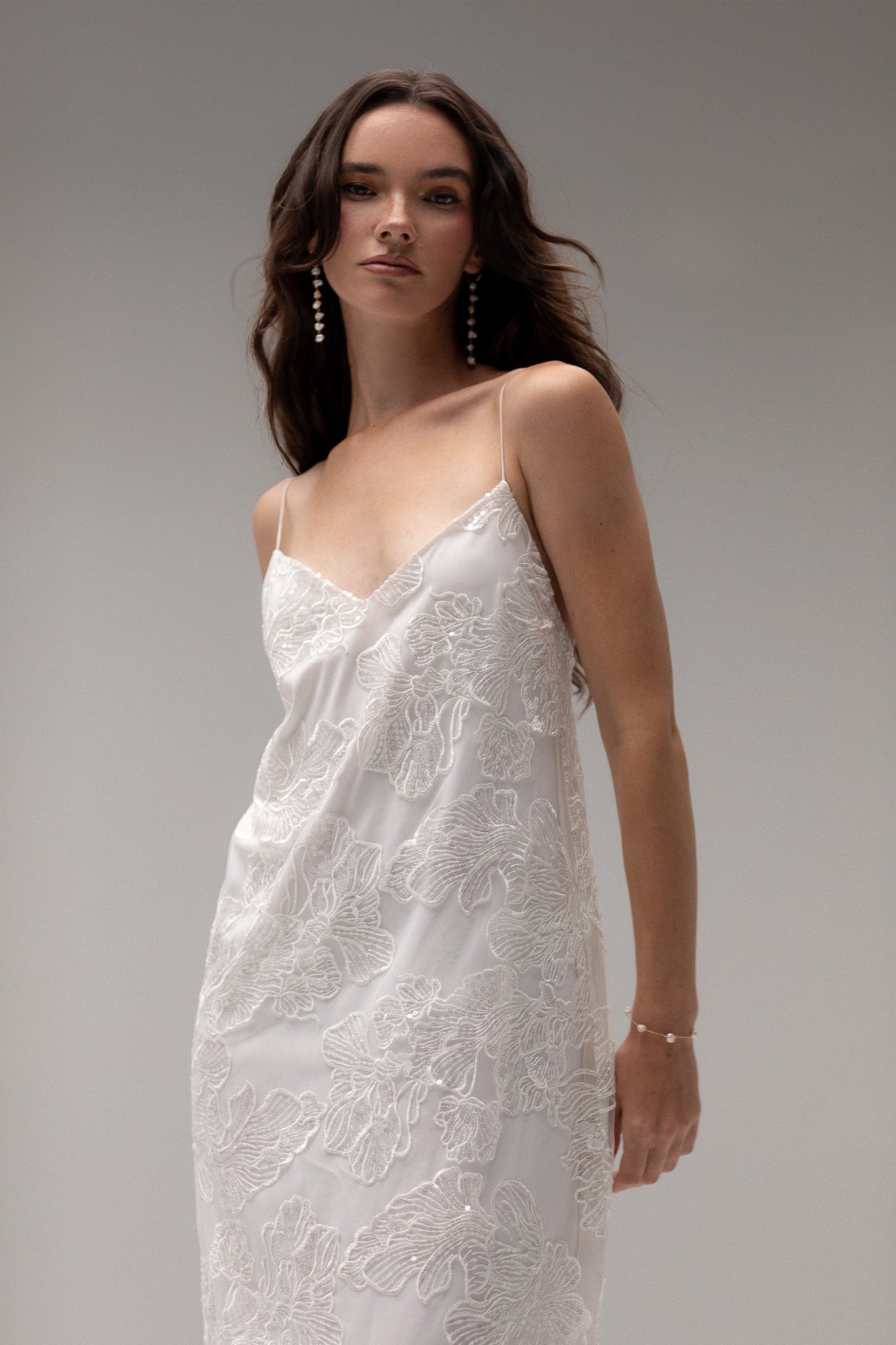 Detailed view of TEMPÊTE maxi bridal dress with delicate sequin lace, v-neck design, spaghetti straps, and an open back, ideal for a modern bridal look