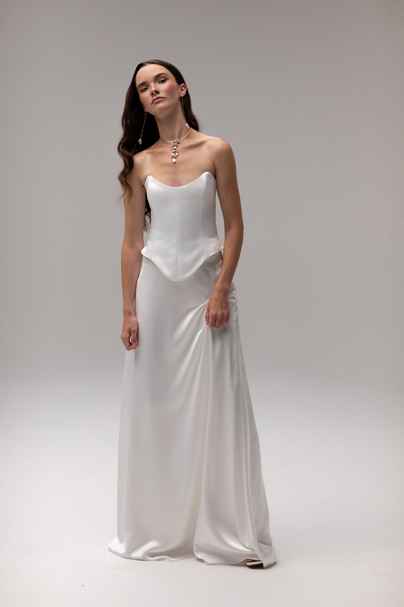 Model wearing a matte satin maxi skirt from the J'OSE Collection by TEMPÊTE, featuring a high-waisted design with a flowing silhouette, perfect for a refined bridal look.