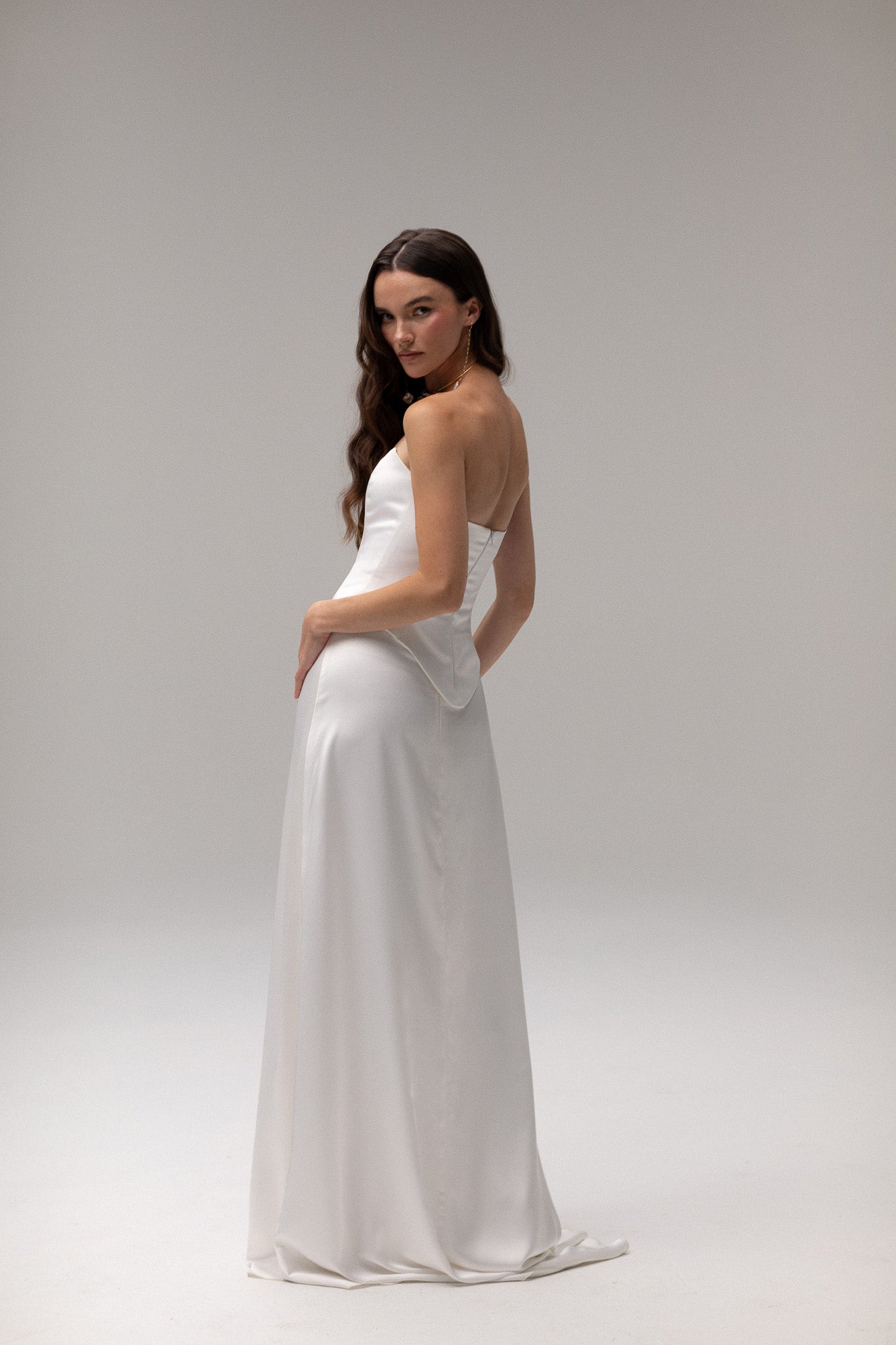 Model wearing a matte satin maxi skirt from the J'OSE Collection by TEMPÊTE, featuring a high-waisted design with a flowing silhouette, perfect for a refined bridal look.