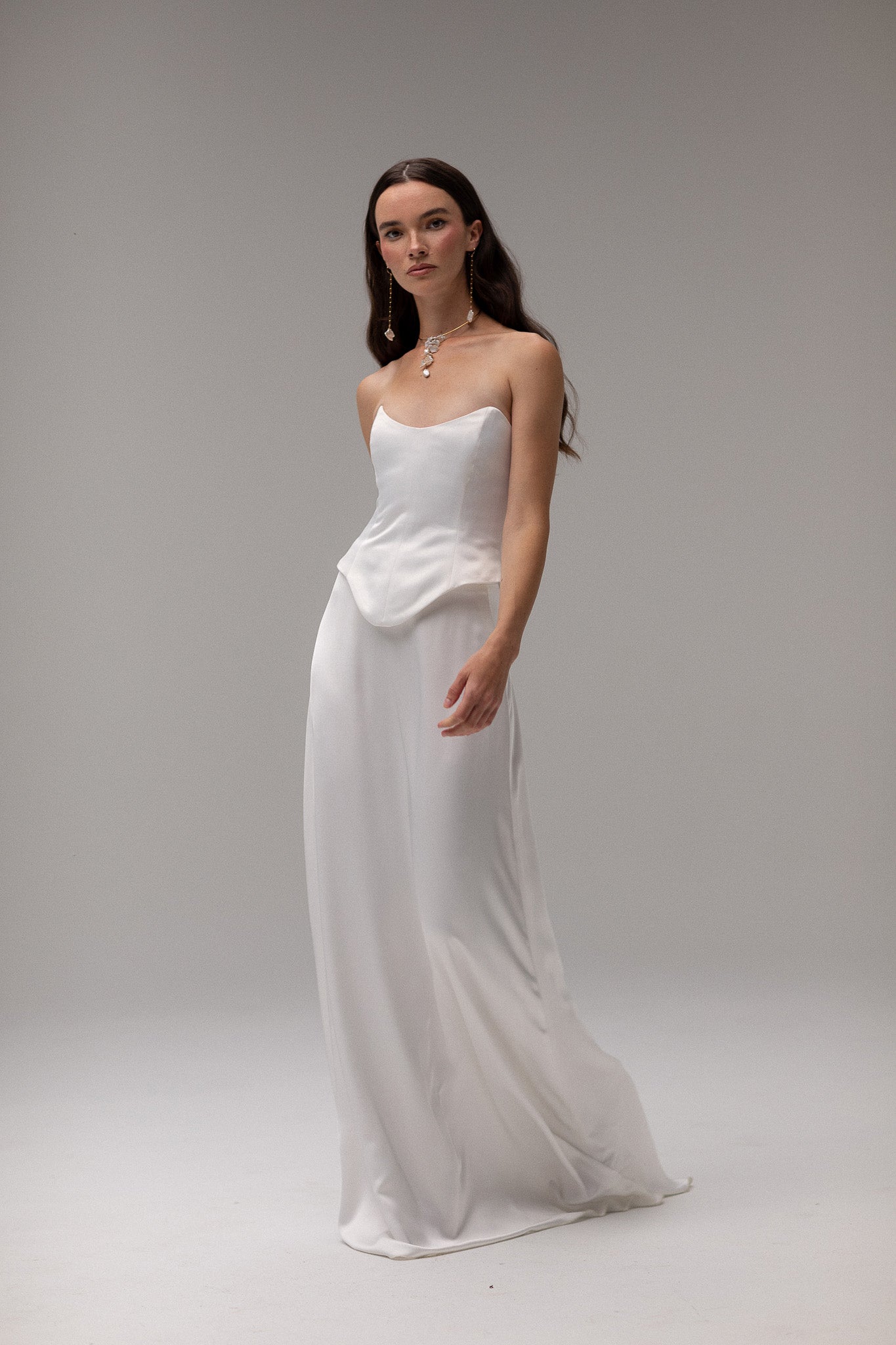 Model wearing a matte satin maxi skirt from the J'OSE Collection by TEMPÊTE, featuring a high-waisted design with a flowing silhouette, perfect for a refined bridal look.