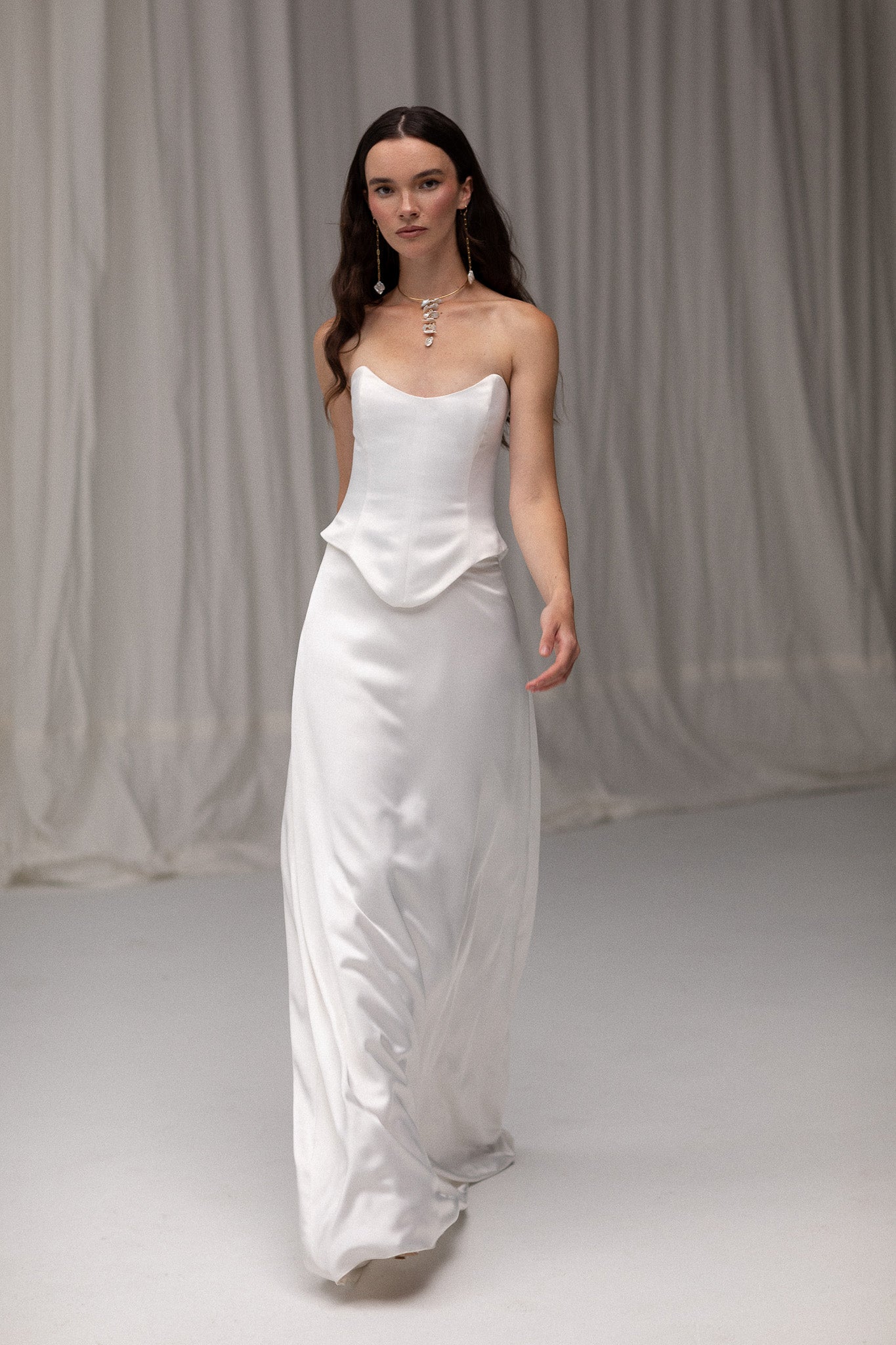 Model wearing a matte satin maxi skirt from the J'OSE Collection by TEMPÊTE, featuring a high-waisted design with a flowing silhouette, perfect for a refined bridal look.