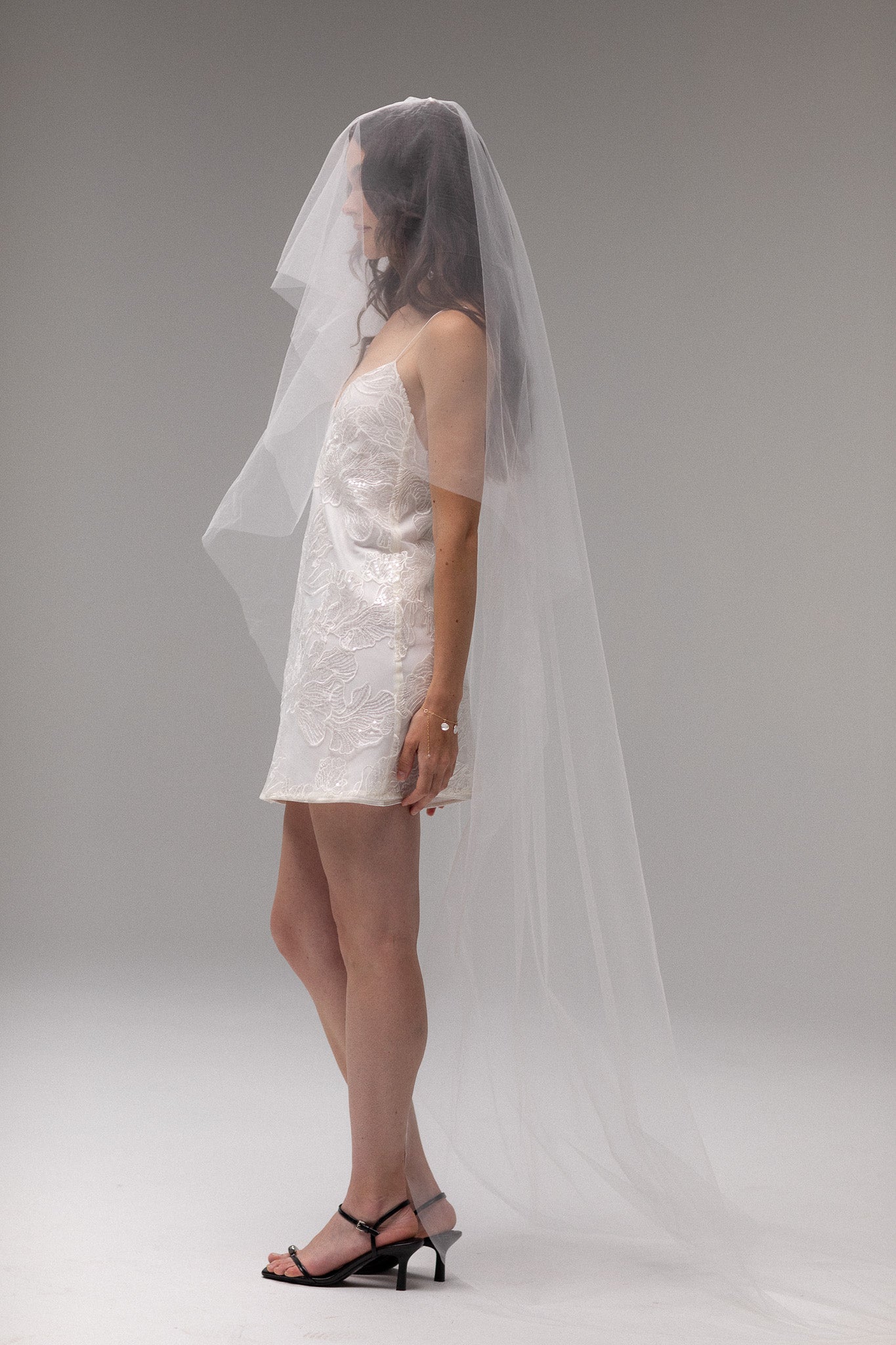 Bride in TEMPÊTE’s short blusher tulle veil, showcasing a minimal design that pairs beautifully with any bridal look.