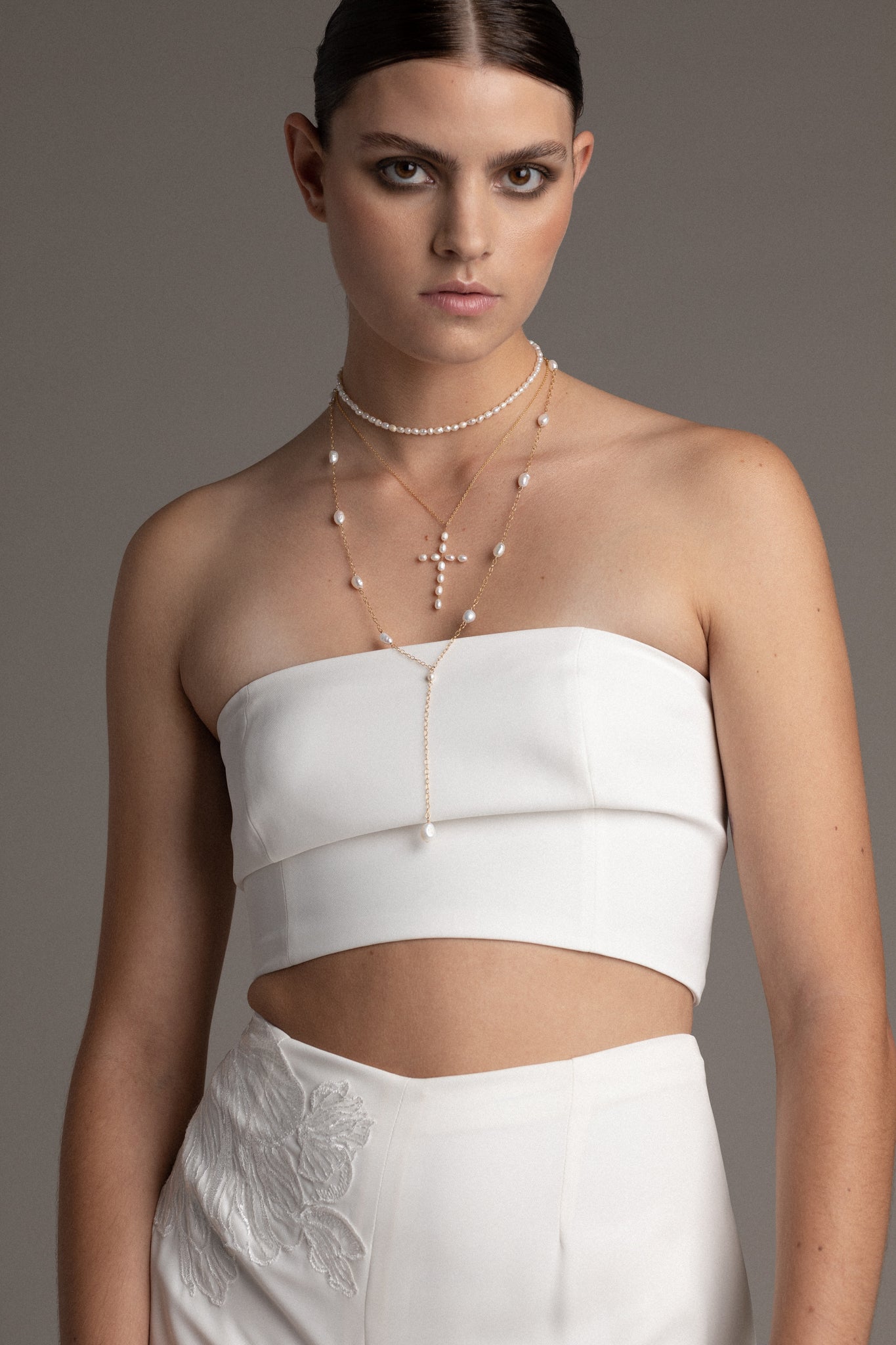 This necklace features a captivating arrangement of freshwater pearls delicately strung along the chain. 