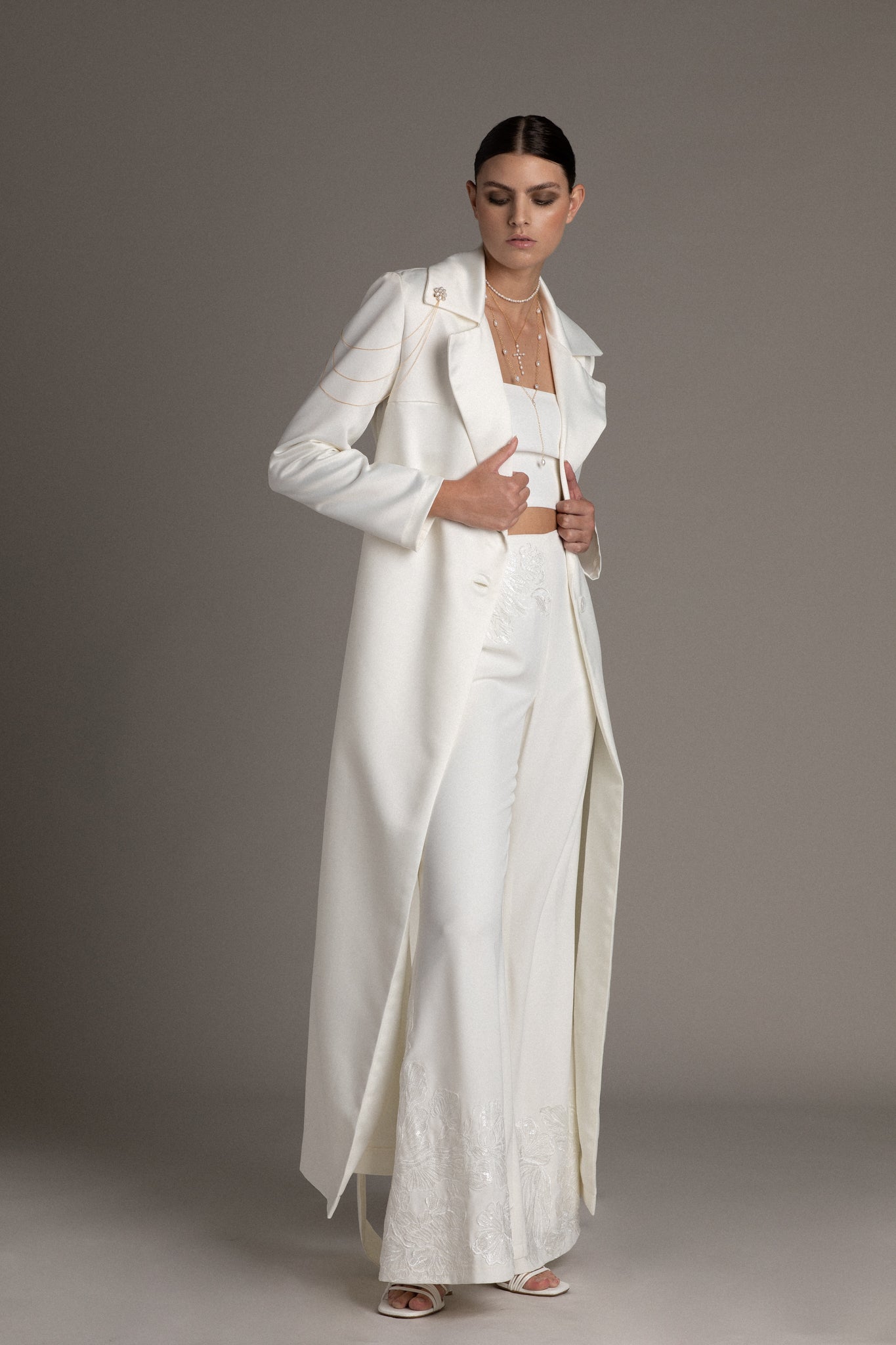 The mother-of-pearl buttons and substantial belt are perfectly complemented by the opulent Duchess Satin. Designed with a relaxed fit, it's tailored for the cool and confident bride.