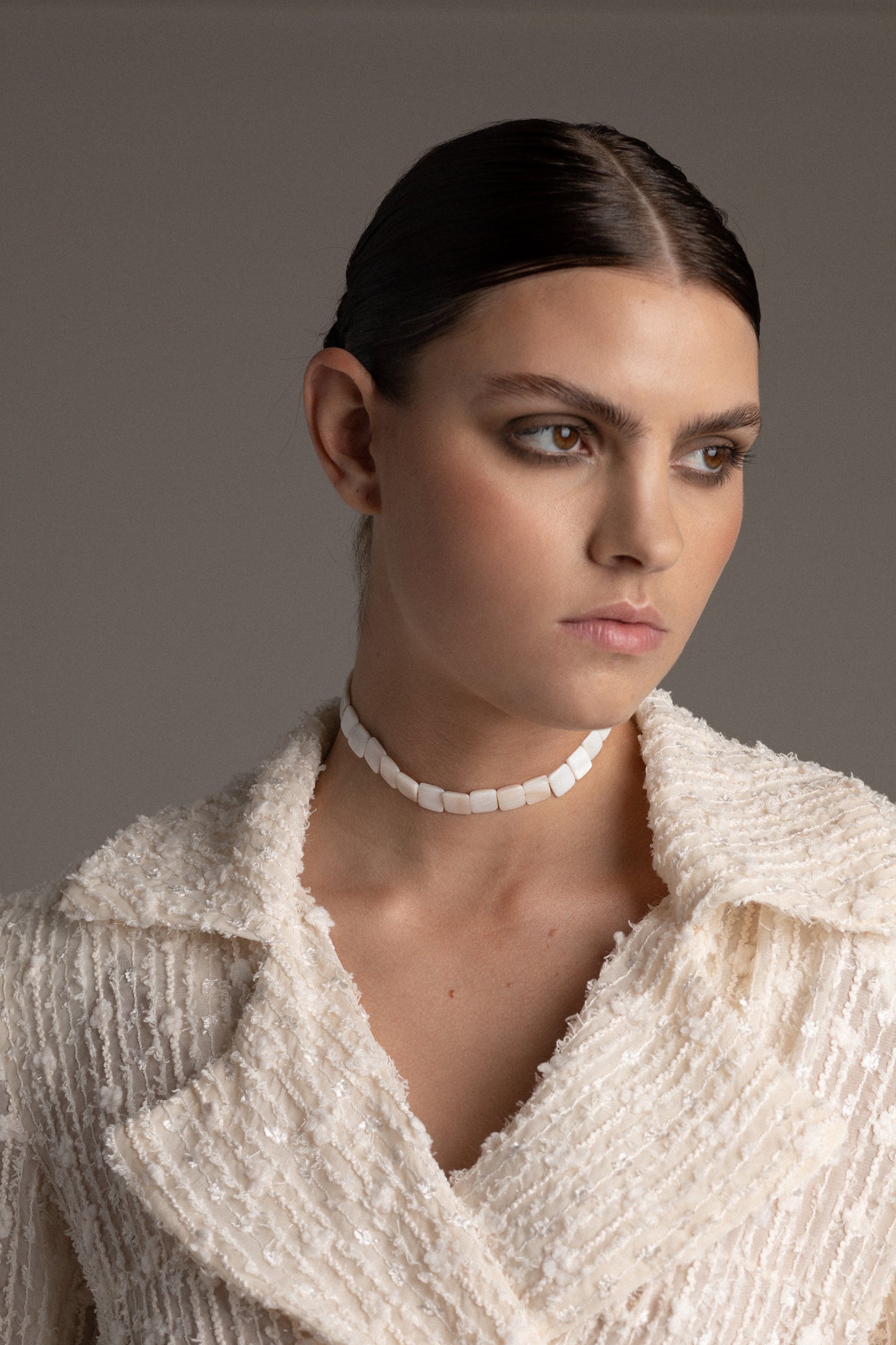 Crafted from genuine mother-of-pearl shells, this choker features square-shaped natural shell beads that capture a distinctive charm. 