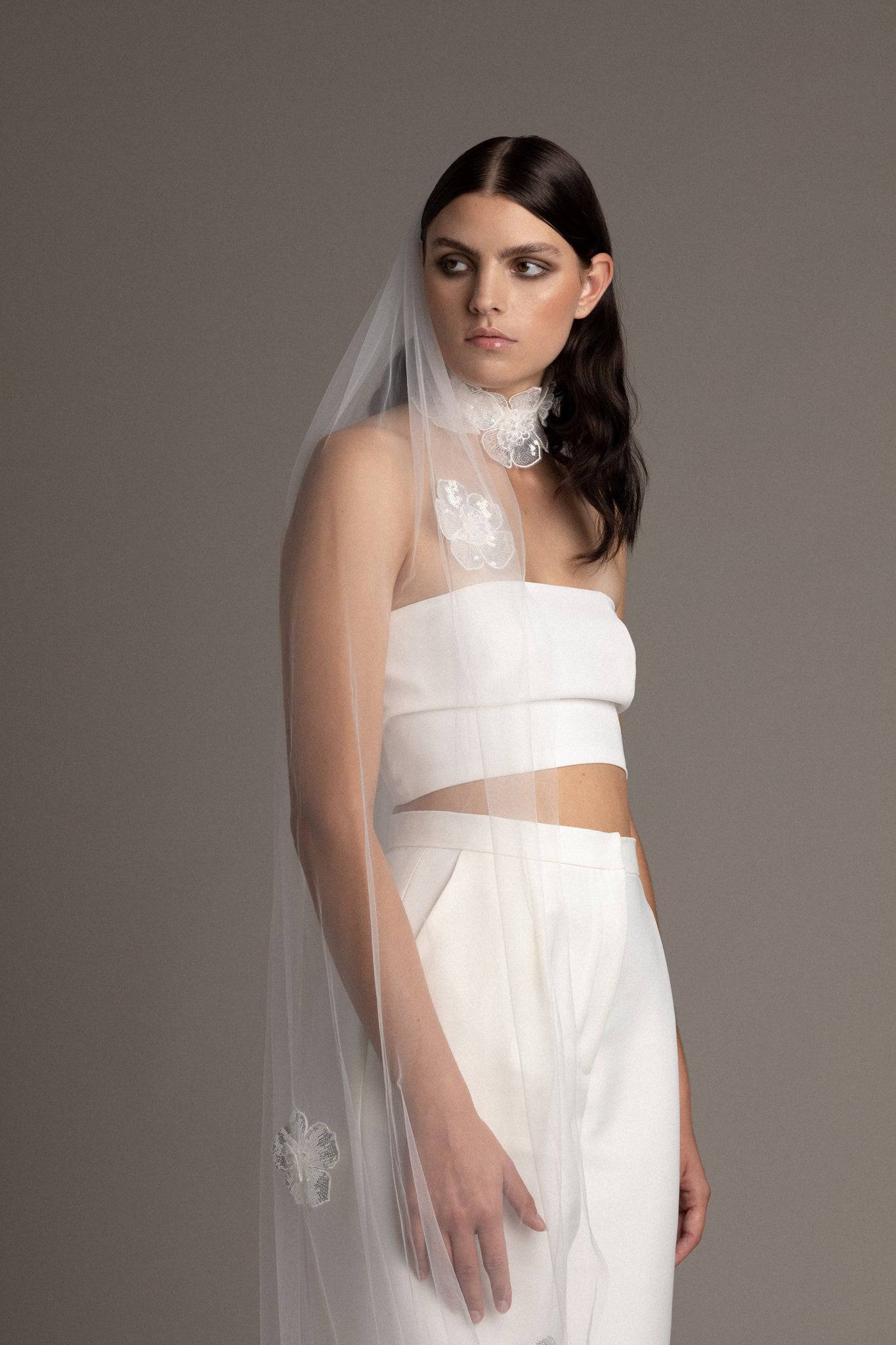 Bride wearing the Sequin Flower Tulle Veil by TEMPÊTE, featuring delicate sequin flowers that span the length of the veil