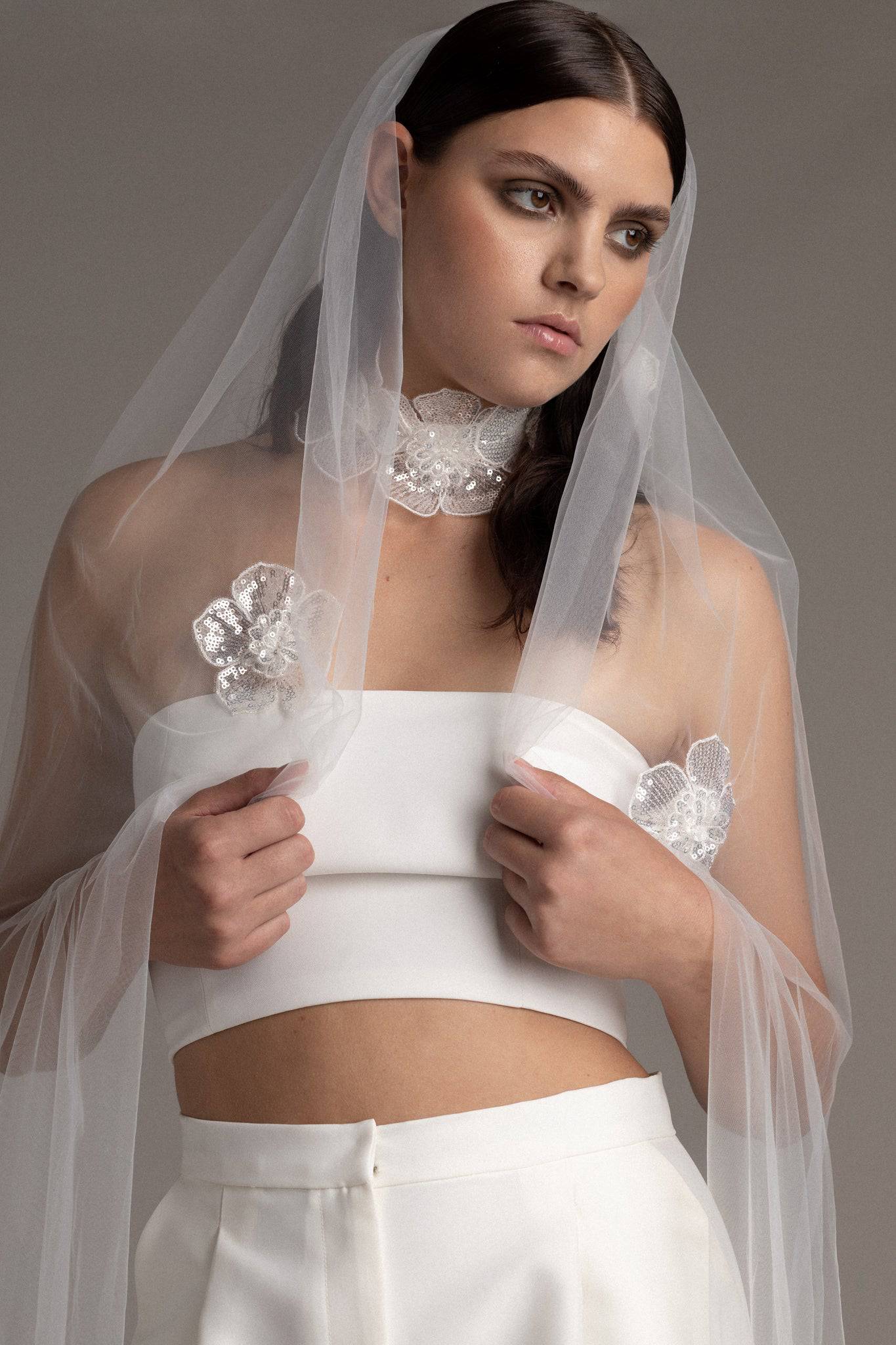 Close up of a bride wearing the Sequin Flower Tulle Veil by TEMPÊTE, featuring delicate sequin flowers that span the length of the veil