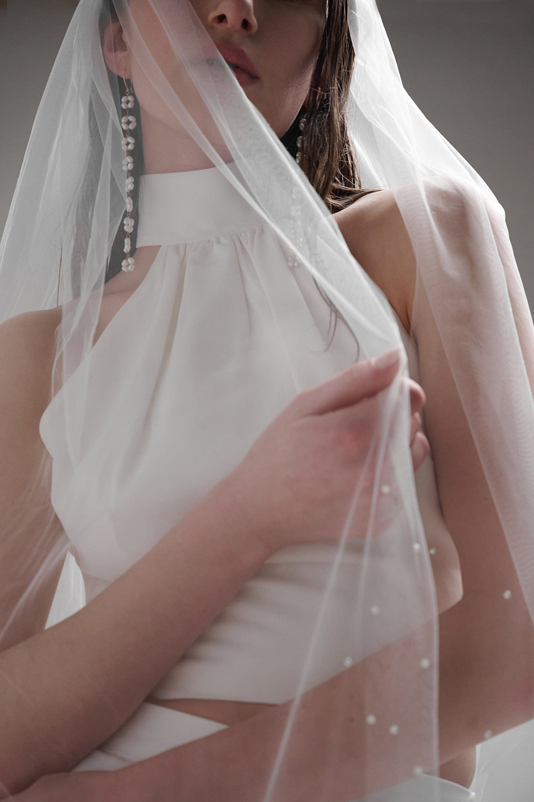 A delicate and elegant veil with scattered pearls that extends down to the chapel length, perfect for a timeless and romantic bridal look.
