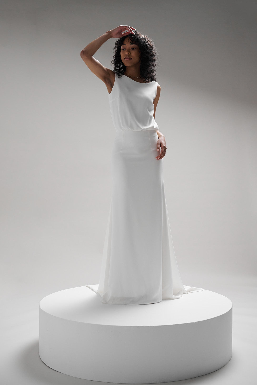 Gaube dress features low back and bodice that drapes gently across the bust, meeting a high snug waistline for an elegant silhouette. 