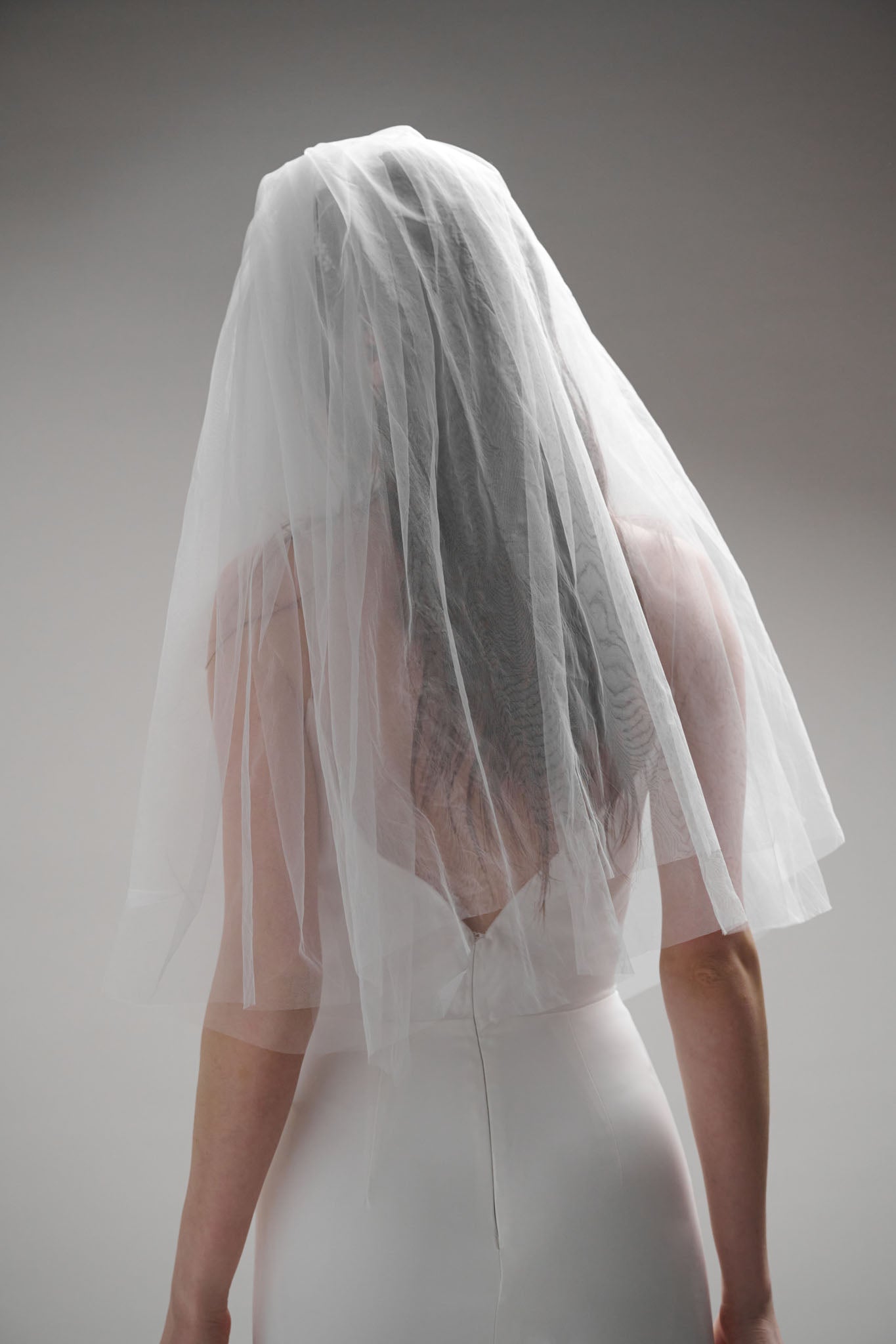 A playful, 60s-inspired veil featuring two 30-inch blunt layers of fine tulle, finished with a gold comb.