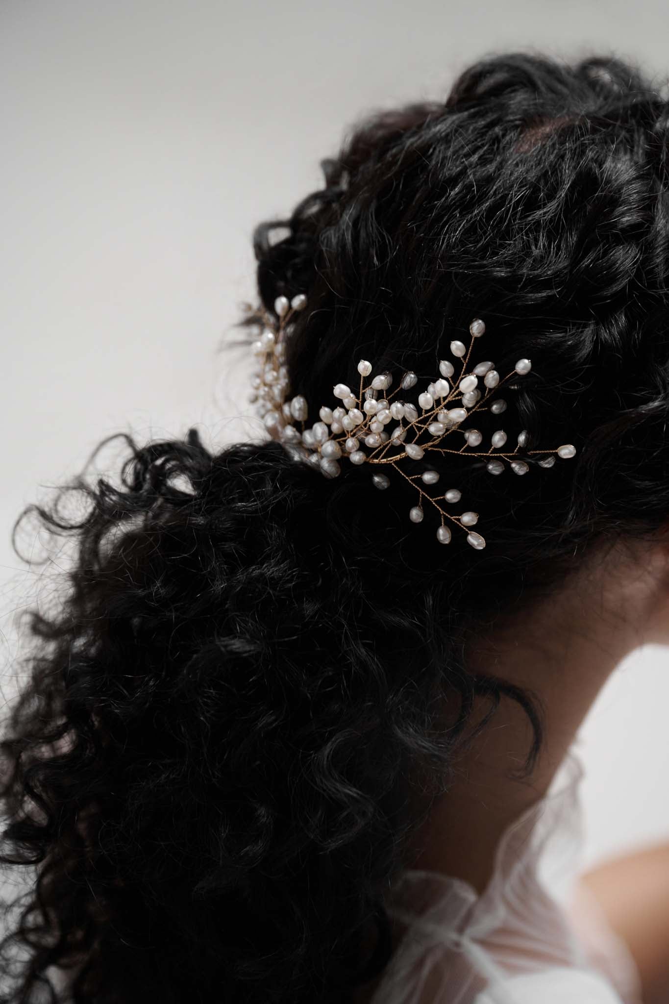 The Cloudburst Hairpiece beautifully combines freshwater pearls and golden branches with a pearly floral centrepiece. 